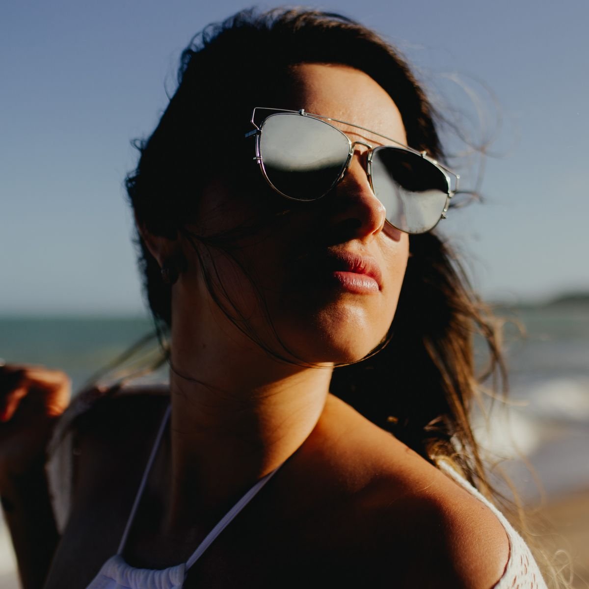 Foto ilustrativa de mulher usando óculos escuros em uma viagem